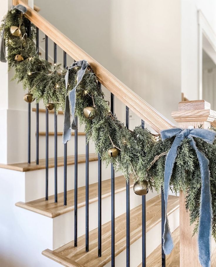 christmas garland on the banisters with bells and bells hanging from it's handrail