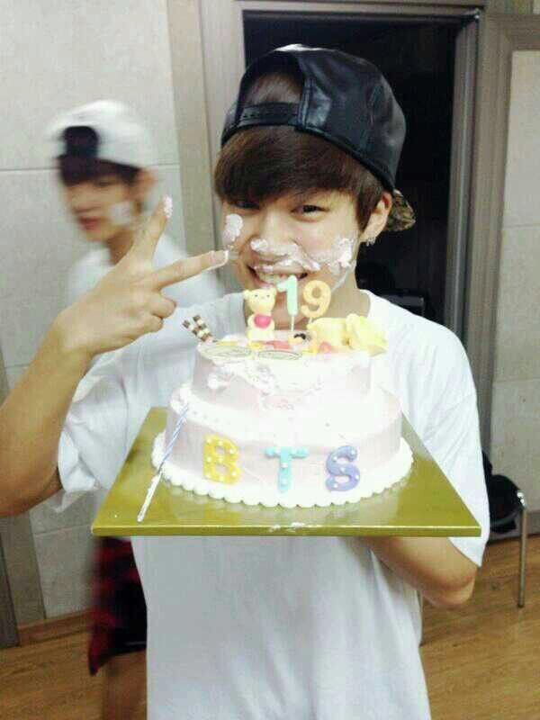 a young man holding a cake with the number 20 on it