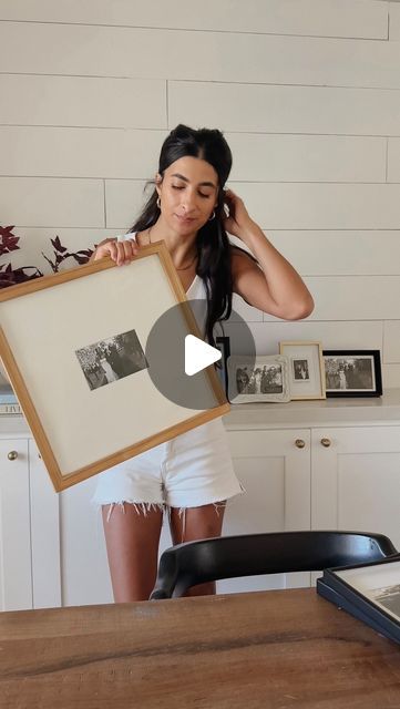 a woman holding up a framed photo in front of her face