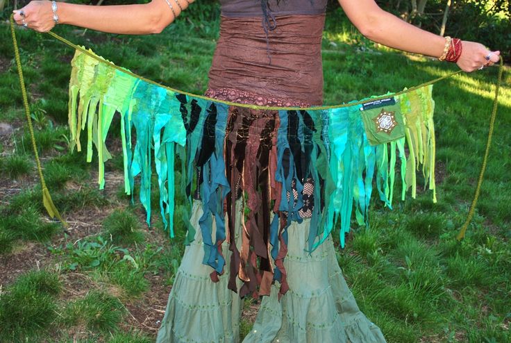 a woman is dressed up as a fairy with green and blue streamers on her skirt