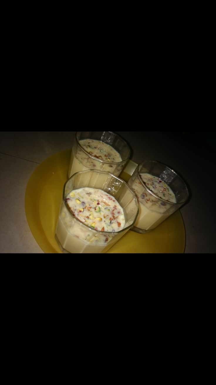 three glasses filled with liquid sitting on top of a yellow plate