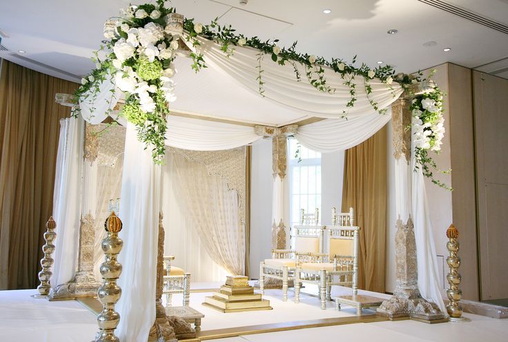 a white and gold wedding ceremony setup with flowers