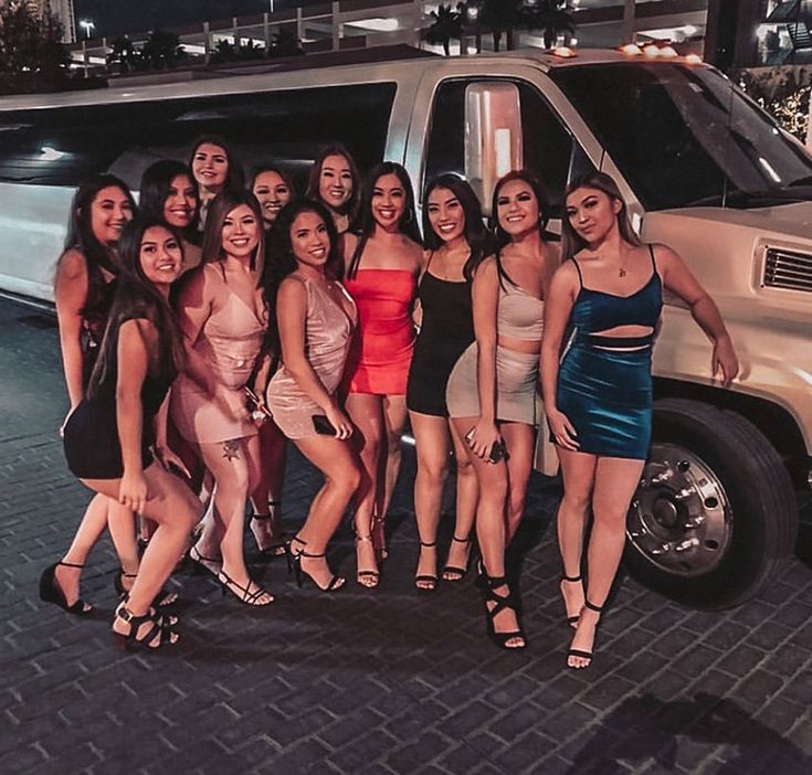 a group of young women standing next to each other in front of a white van