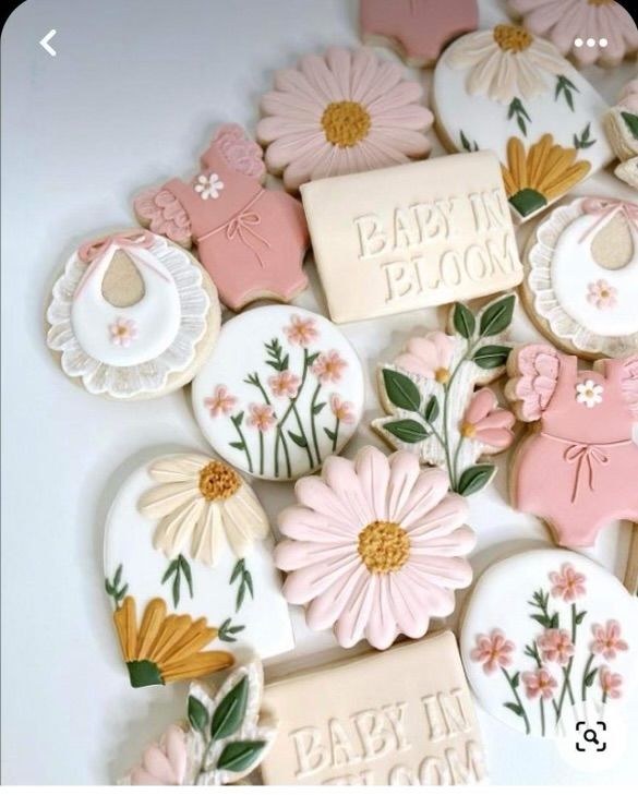 baby in bloom decorated cookies are displayed on a table