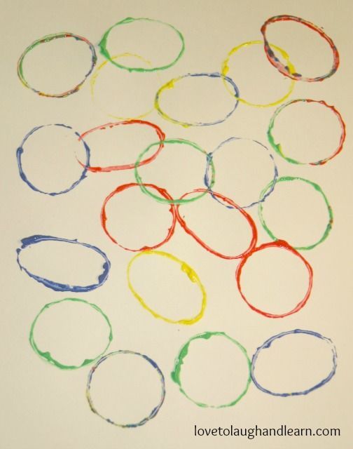 there are many different colored circles on the white paper that is drawn with crayons