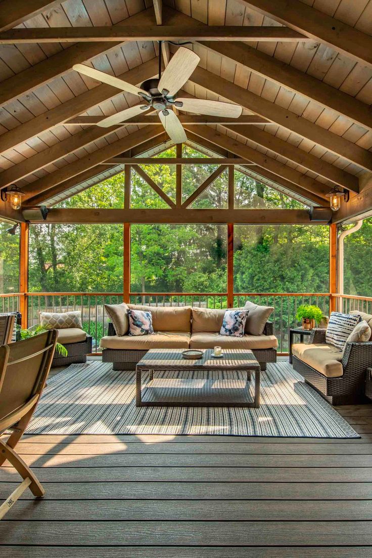 a covered deck with furniture and ceiling fan