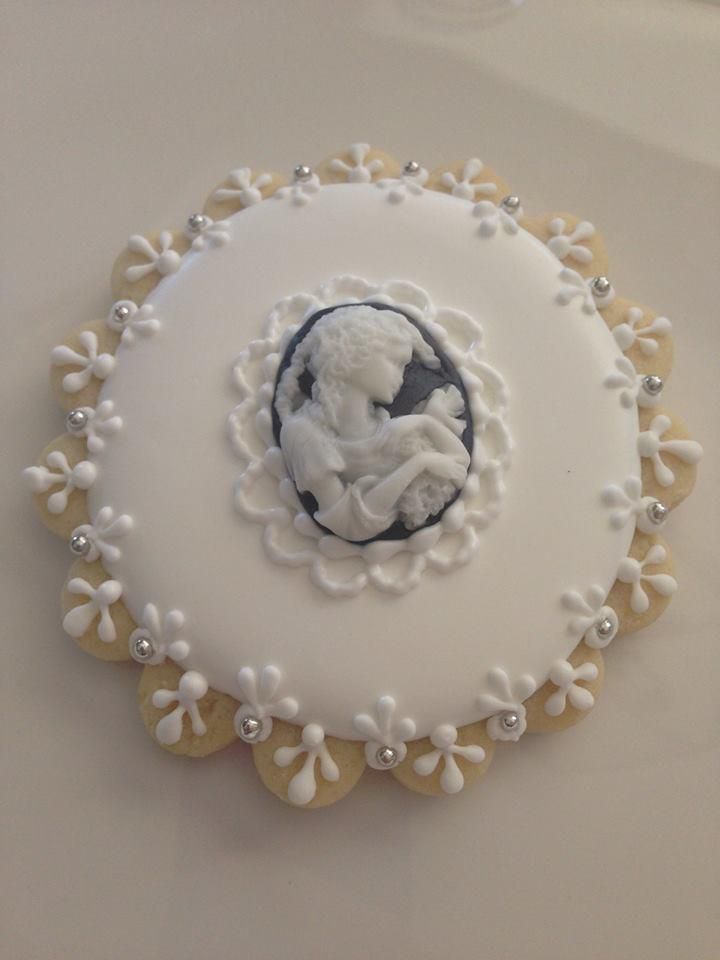 a white and gold decorated cake with an image of a baby on it's side