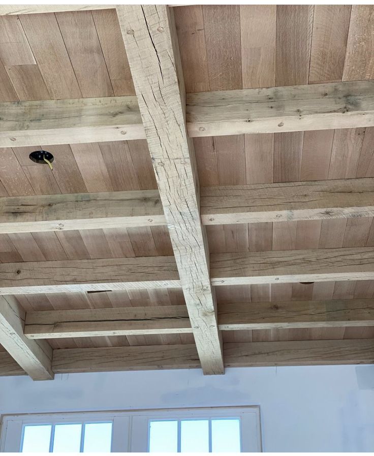 an unfinished ceiling with wooden beams and windows