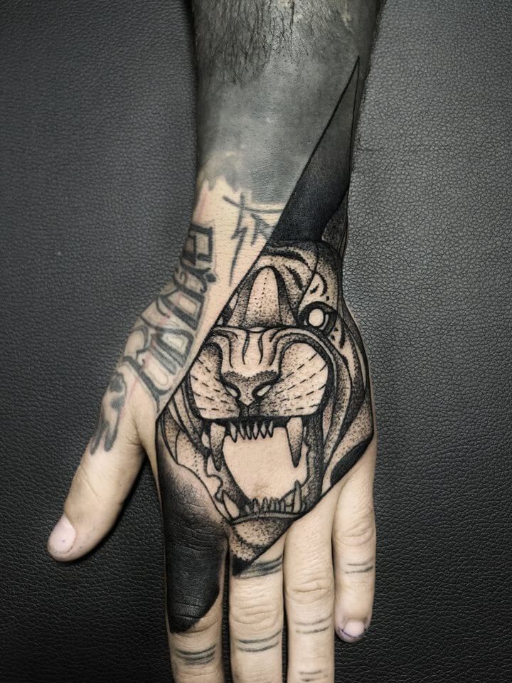 a man's hand with a tattoo on it and a tiger head in the middle