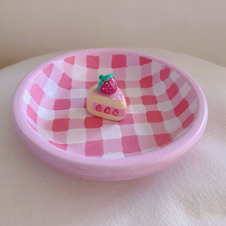 a pink and white checkered plate with a piece of cake on it's side