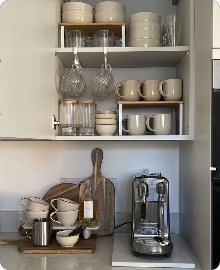 the shelves in the kitchen are filled with dishes and coffee pots, cups, and mixers