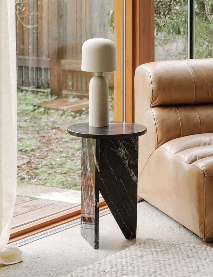 a living room with a couch, chair and table in front of a sliding glass door