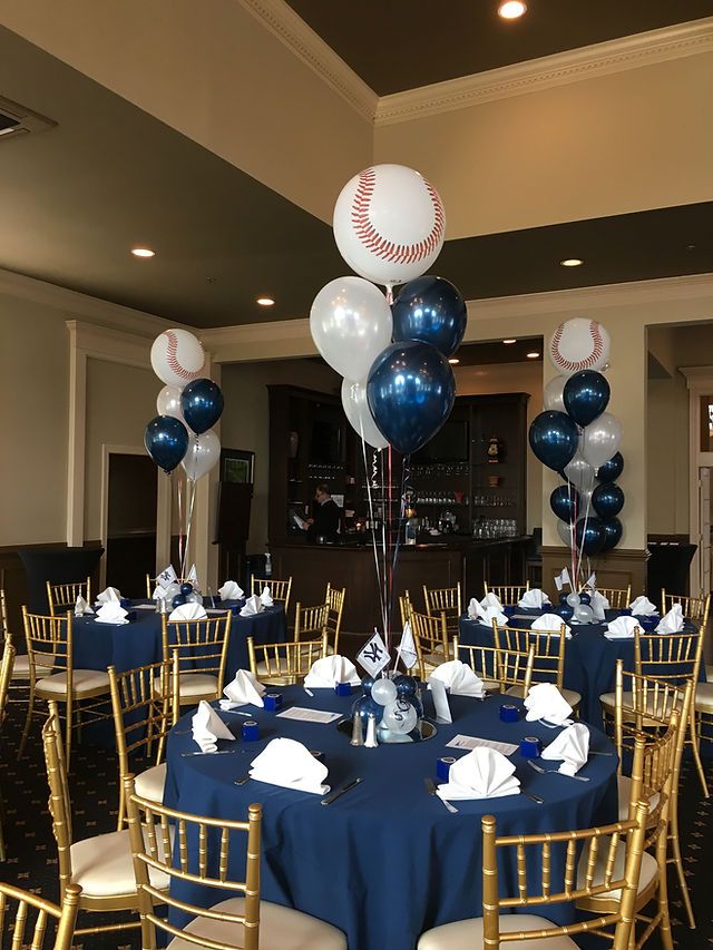 a baseball themed party with blue table cloths and gold chairs, balloons and napkins