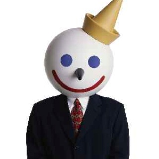 a man in a suit and tie with a clown mask on his head wearing a gold crown