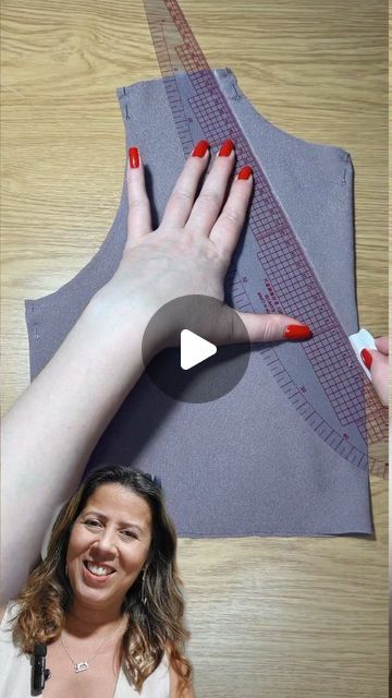 a woman with red nail polish on her nails is making a hand gesture over a piece of fabric