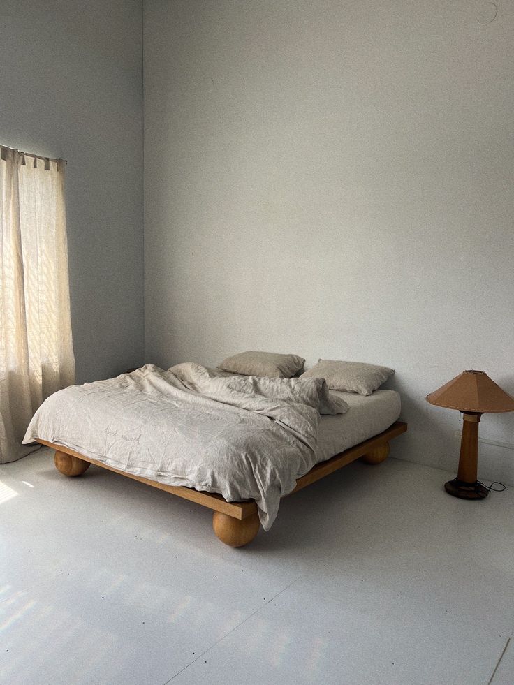 a bed sitting next to a lamp in a bedroom