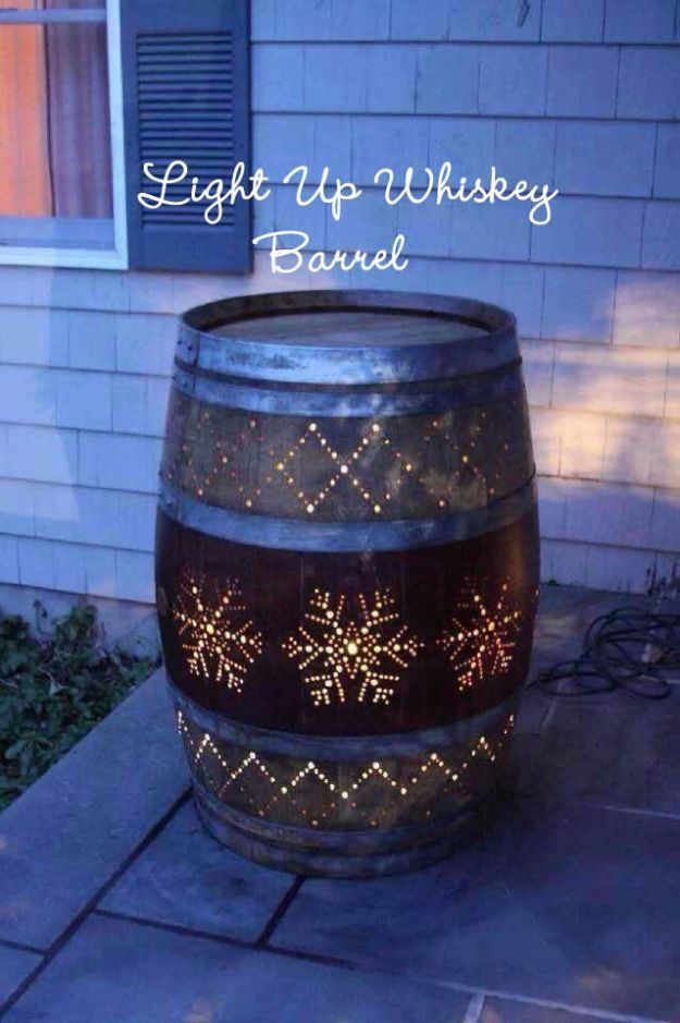 a wine barrel with snowflakes on it sitting in front of a house at night