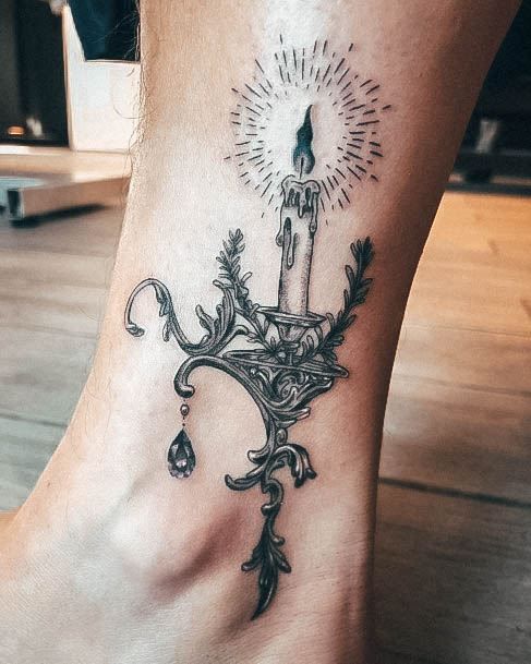 a foot with a candle tattoo on it