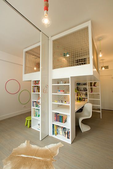 there is a loft bed in the middle of this room with bookshelves and shelves