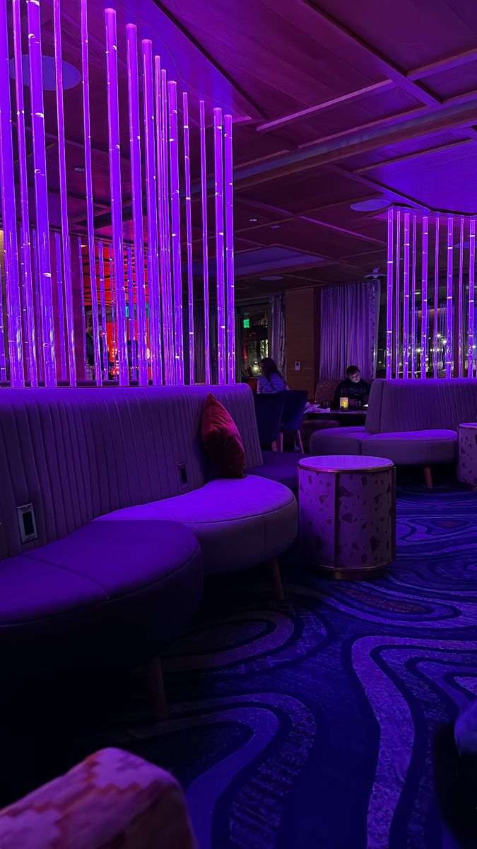 a room with purple lighting and couches in it