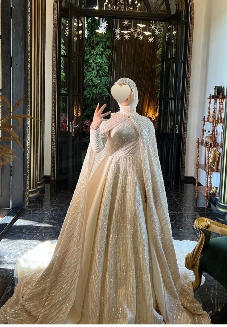 a woman in a white gown standing next to a doorway