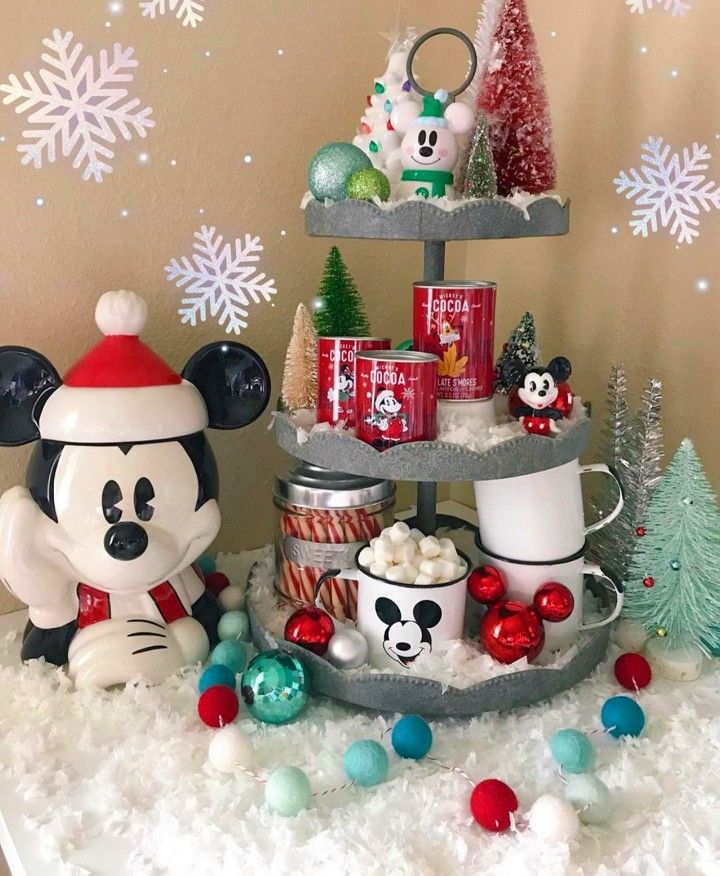 there is a christmas tree with mickey and minnie mouse decorations on it in the snow