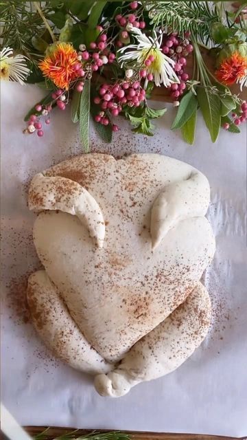 a heart shaped pastry sitting on top of a table next to flowers