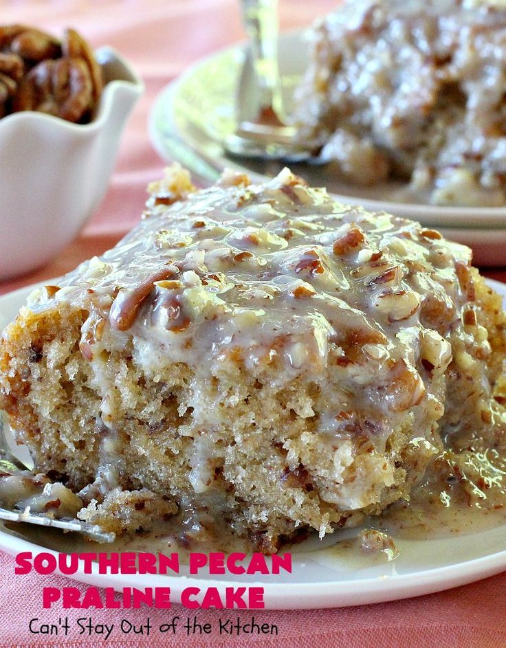 a piece of cake on a plate with pecan icing and nuts in the background