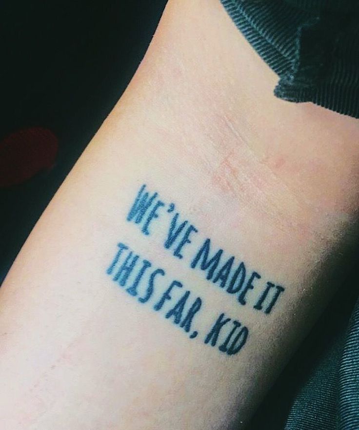 a person with a tattoo saying we've made it this far, kid