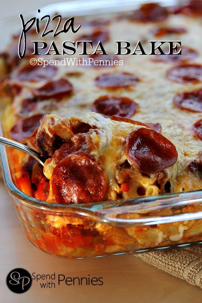 a pizza casserole with pepperoni and cheese in a glass dish on a wooden table