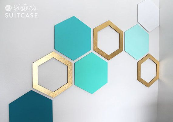 the wall is decorated with hexagons and gold frames in different colors on it