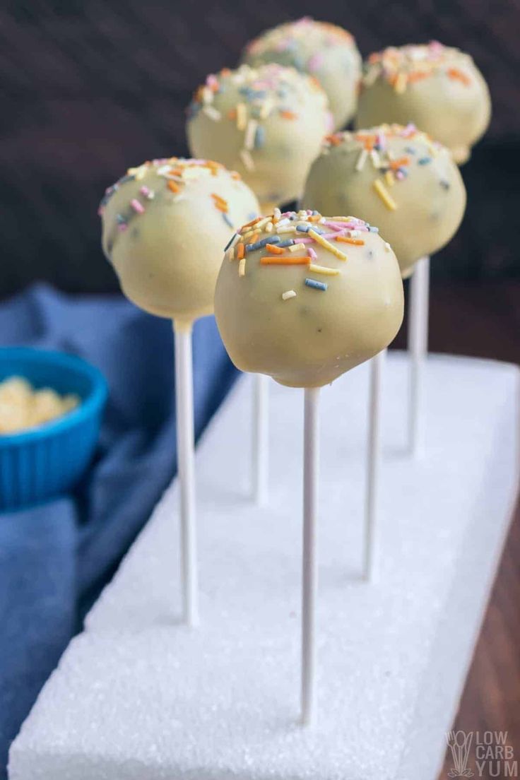 cake pops with sprinkles are on a white plate