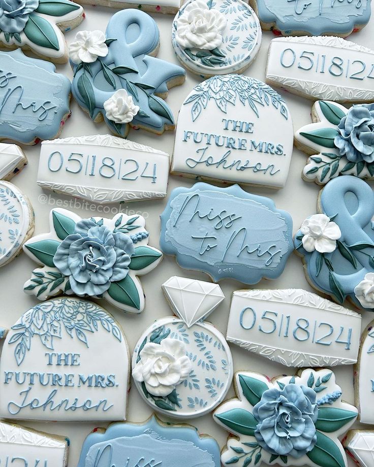 some cookies are decorated with blue and white frosted icing, flowers and leaves