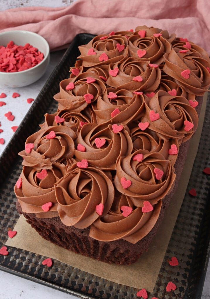 a chocolate frosted cake with pink hearts on it