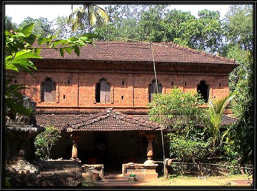 an old brick building surrounded by trees and greenery