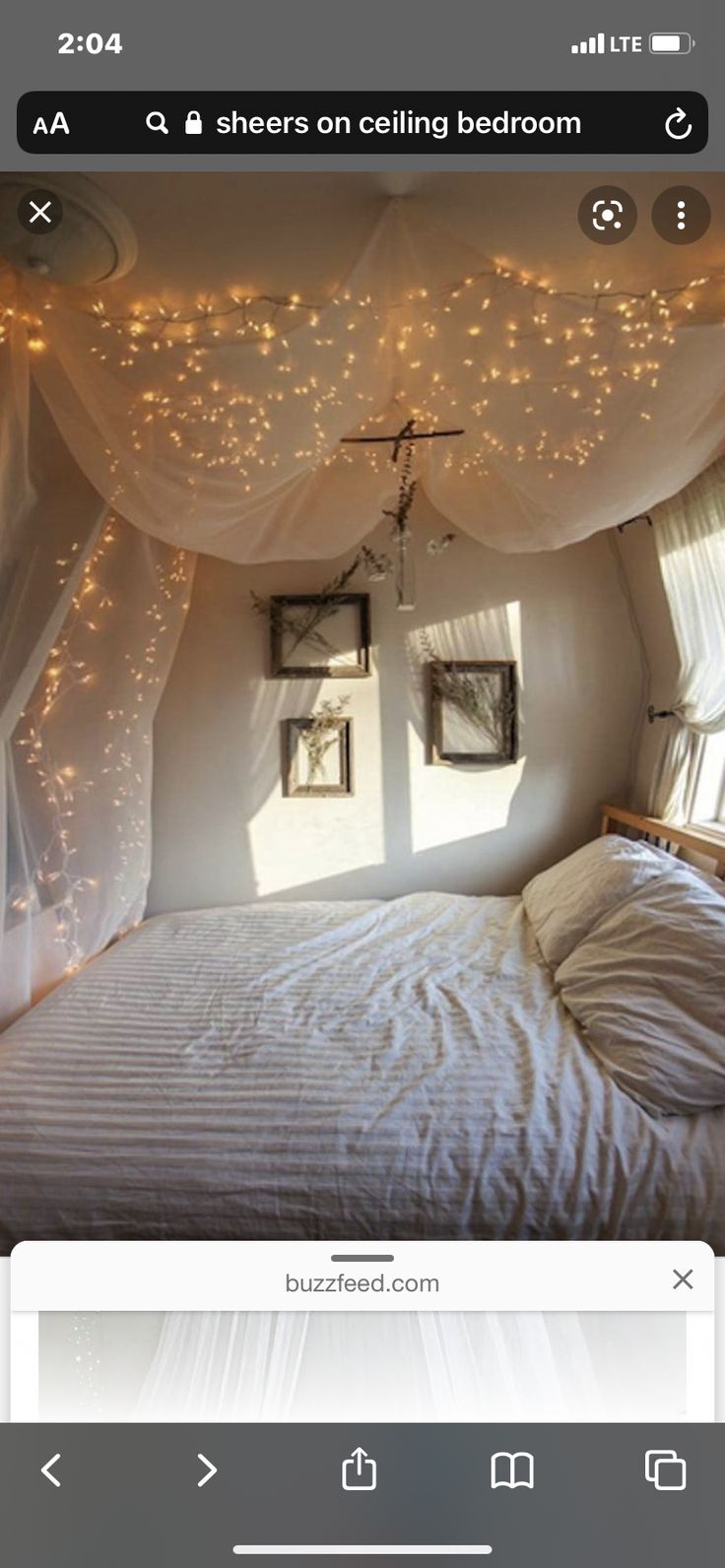 an image of a bedroom with lights on the ceiling and curtains over the bed in the corner