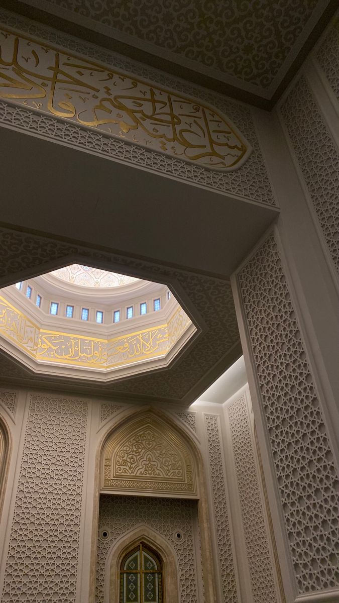 the inside of a building with an intricate ceiling and arches in arabic writing on it