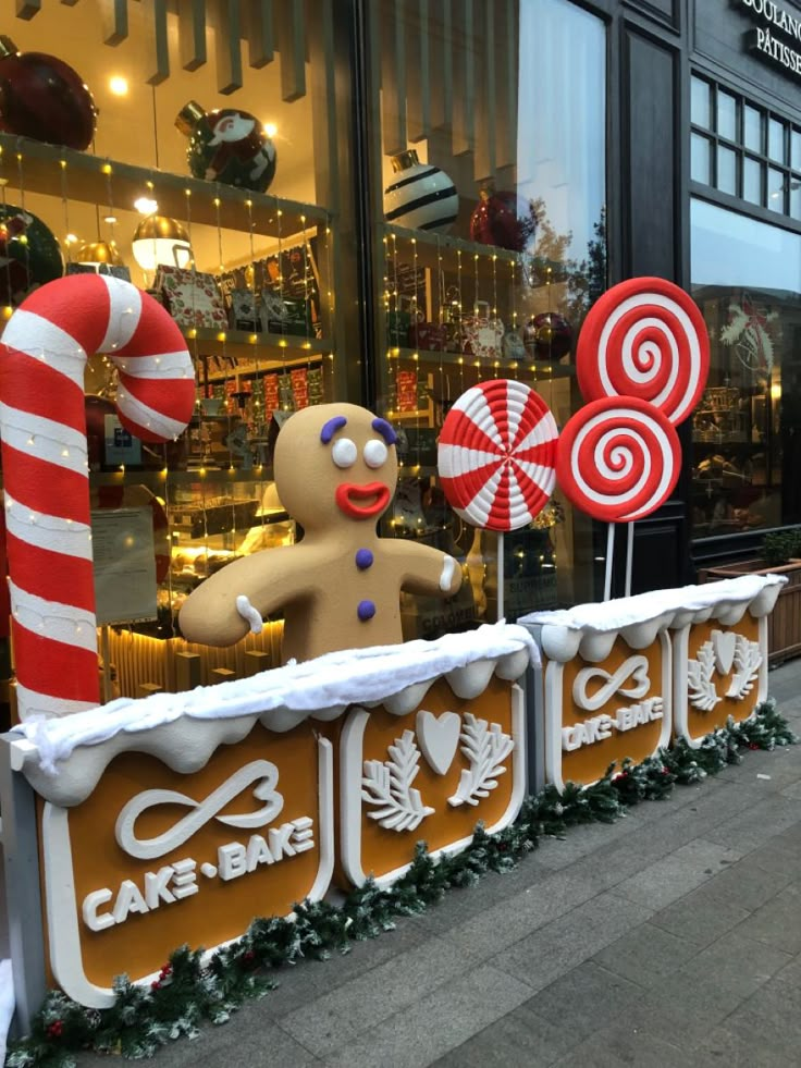 some candy canes and a gingerbread man in front of a storefront window