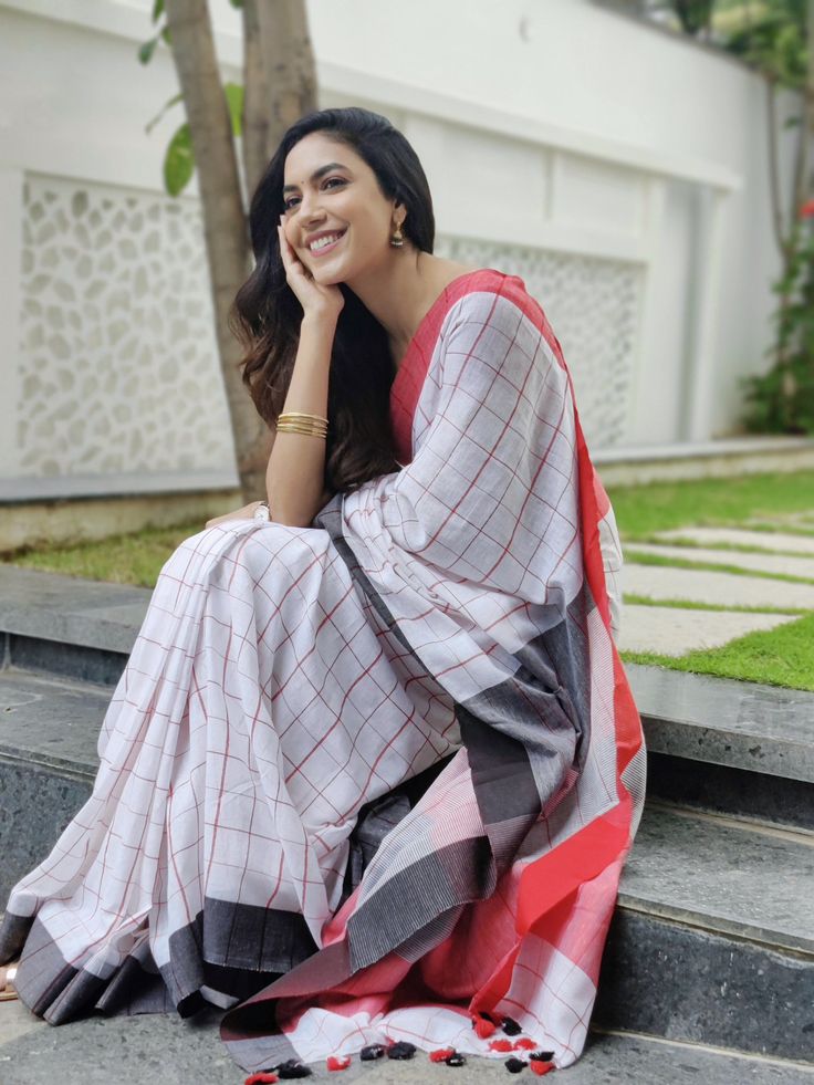 a woman is sitting on the steps in a sari and smiling at the camera