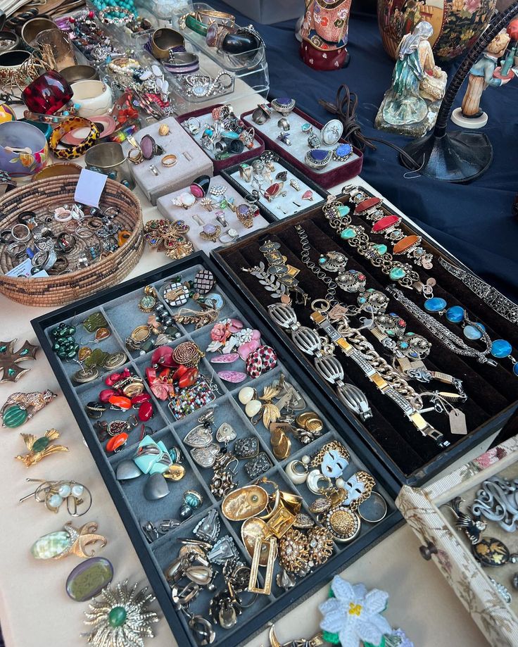 an assortment of jewelry is on display at a flea market with other items in the background