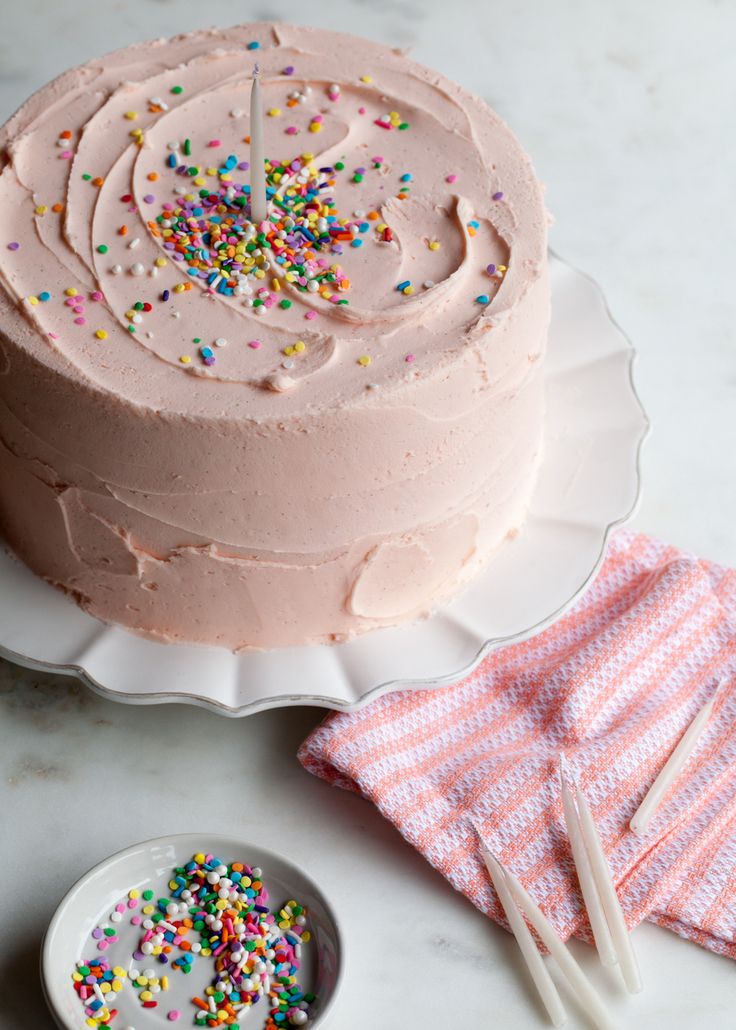 a cake with pink frosting and sprinkles