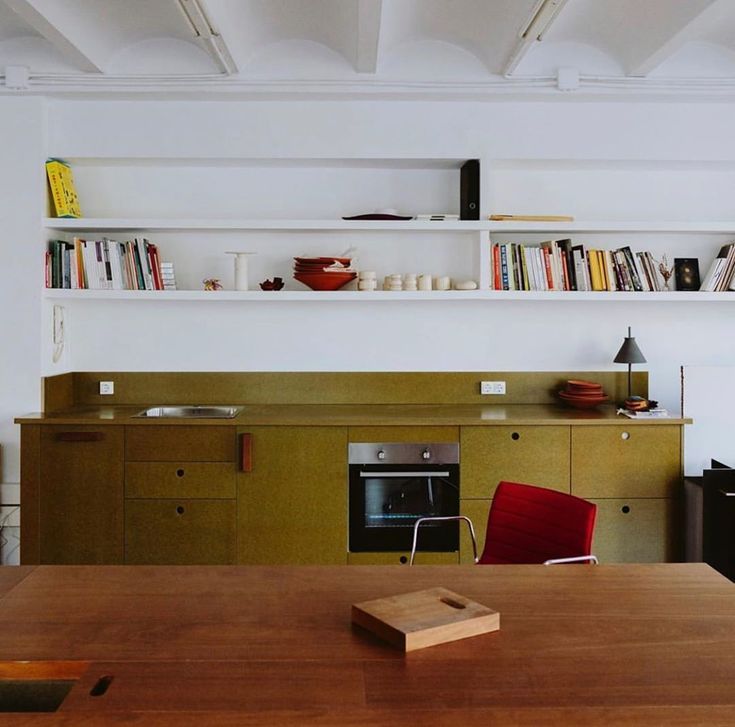 a wooden table sitting in front of a bookshelf