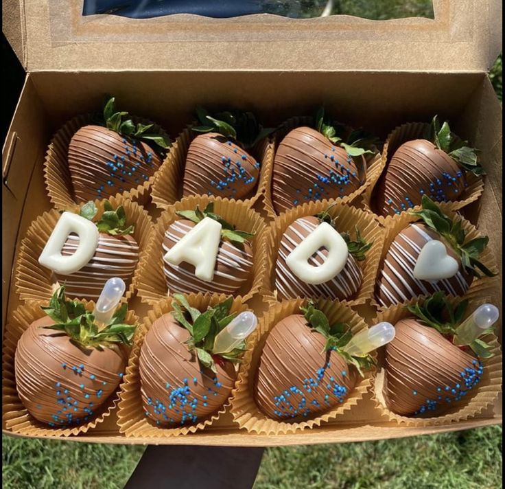 chocolate covered strawberries in a cardboard box with the number six on them and blue sprinkles