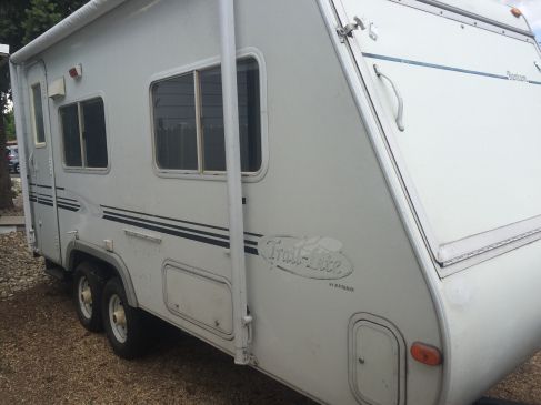 an old camper is parked on the gravel