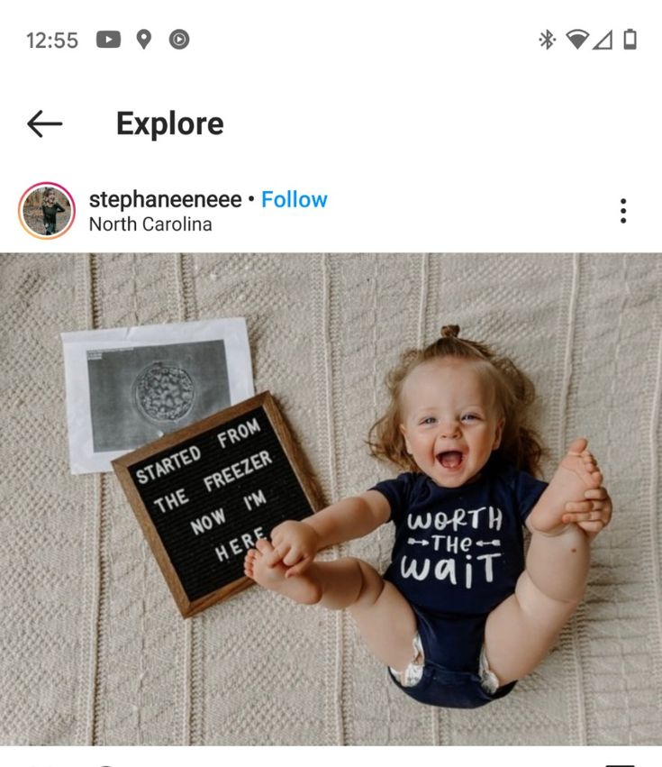 a baby is smiling and holding a sign