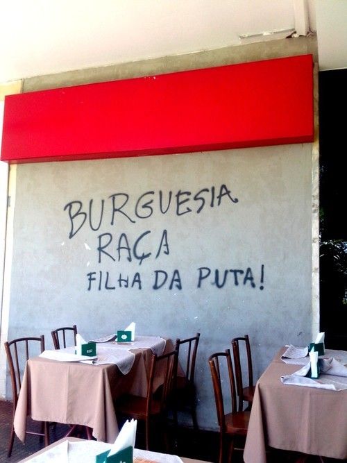 two tables with white tablecloths are in front of a wall that has writing on it