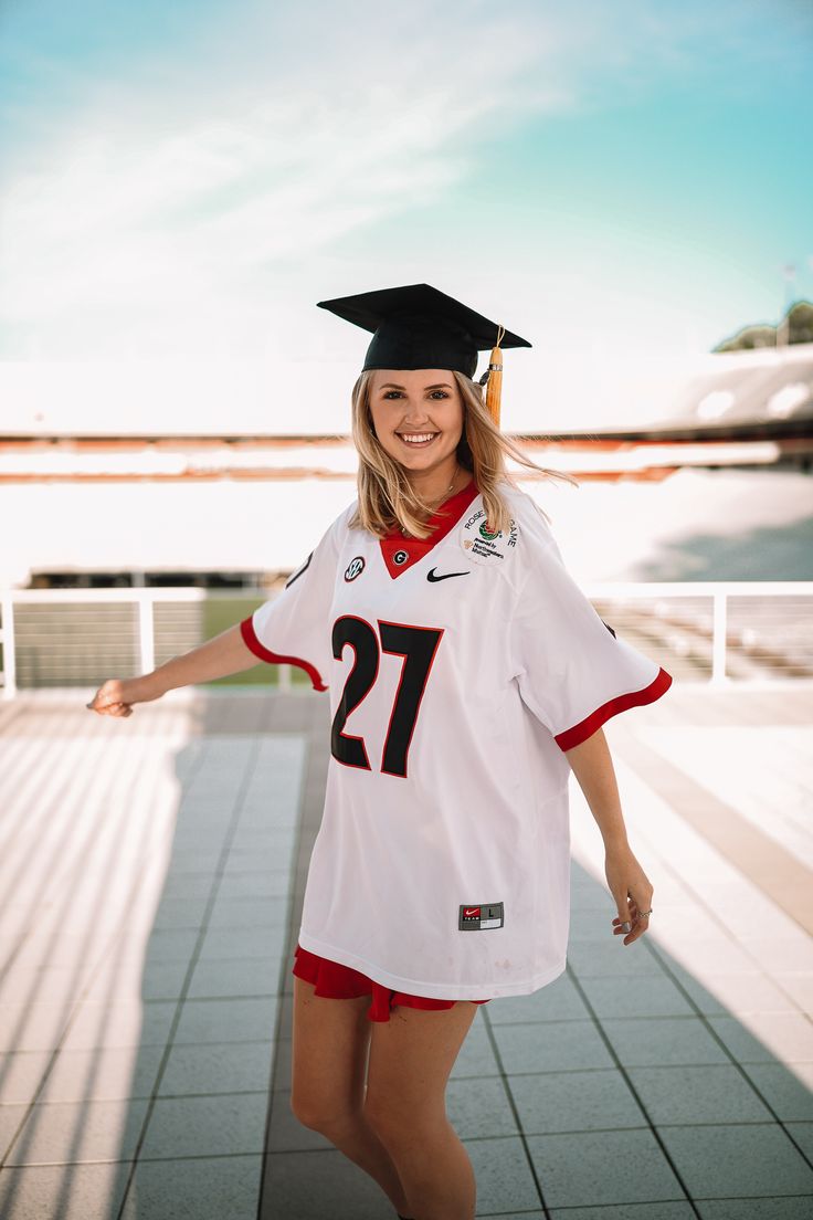 a woman in a graduation cap and gown is posing for a photo with her hand on her hip