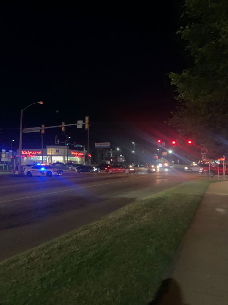 the police car is parked on the side of the road at night with its lights on