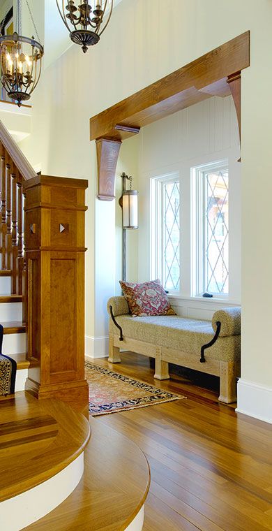 a living room filled with furniture next to a stair case and wooden floored stairs