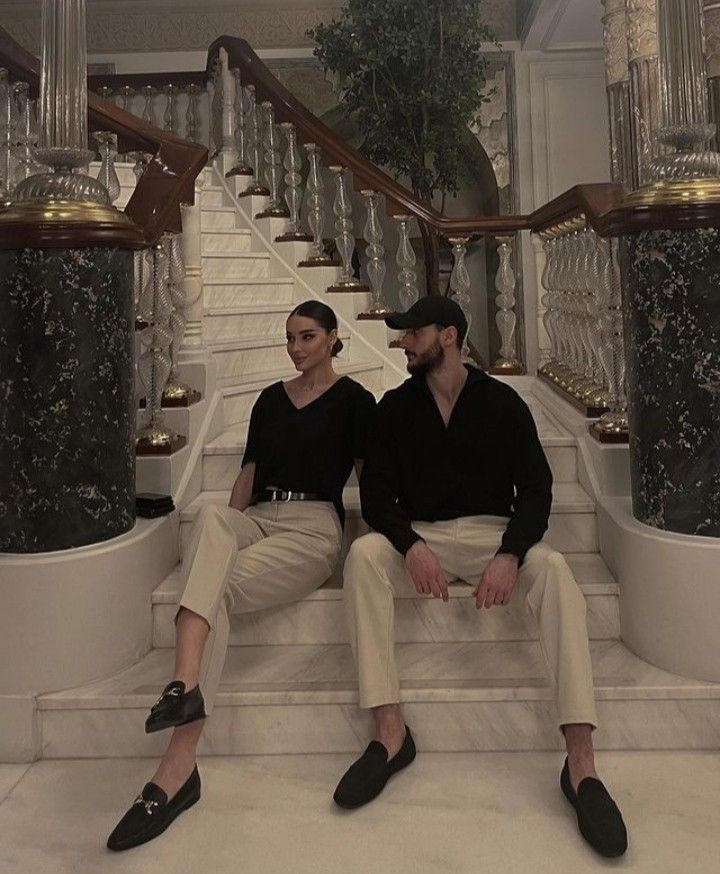 two people sitting on the steps of a staircase